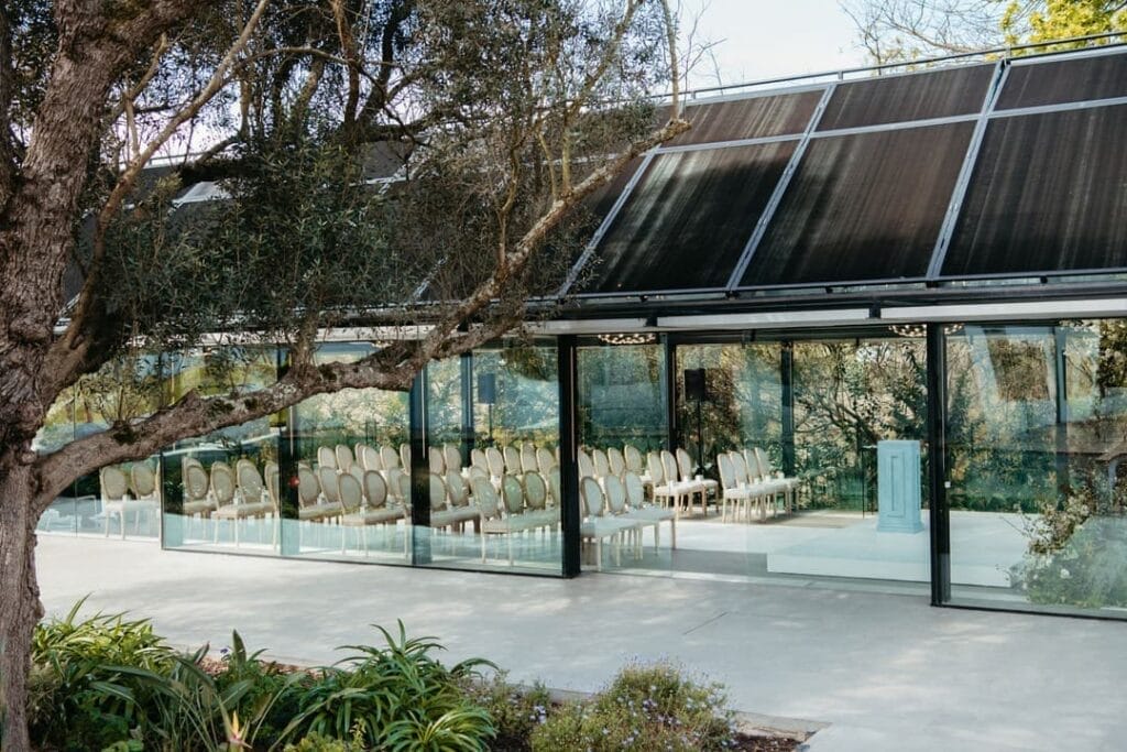 Stellenbosch wedding venues Glass pavilion with chairs set for a wedding at Hazendal